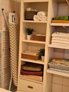 a walk in closet with white shelves and towels at Case Kiyas in Mamoudzou