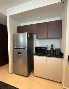 a kitchen with a stainless steel refrigerator and cabinets at Departamento en Monné in Mérida