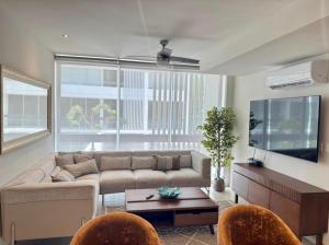 a living room with a couch and a tv at Departamento en Monné in Mérida