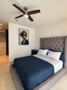 a bedroom with a bed with a ceiling fan at Departamento en Monné in Mérida +5 photos