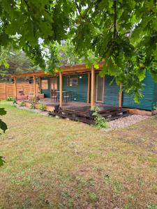 a blue house with a porch and a yard at Przystanek Natura in Gorczyca