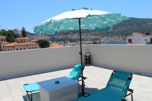 a table and two chairs with an umbrella on a roof at Diogenes Apartments in Samos
