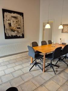 a conference room with a wooden table and chairs at Fredfyldt skovbolig med udespa in Rødding