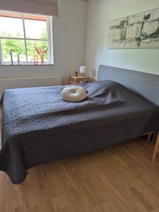 a bed with a pillow on it in a bedroom at Fredfyldt skovbolig med udespa in Rødding