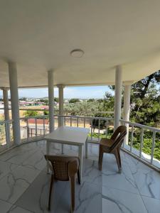 a porch with a white table and two chairs at Narçiçeği in Değirmendere +14 photos