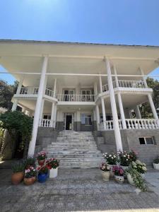 a large white building with stairs and potted plants at Narçiçeği in Değirmendere