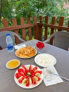 a table with plates of fruit and crackers on it at Koman Rest Point in Koman