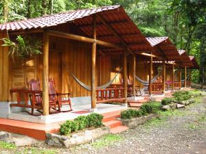 a wooden cabin with rocking chairs in front of it at Recreo Verde Hot Springs & Spa in Marsella
