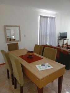 a dining room table with chairs and a mirror at Escalera del éxito Villa Ramallo in Estación Ramallo