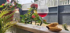 a glass of wine sitting on a wooden ledge with two cookies at Mycircle in Marigot