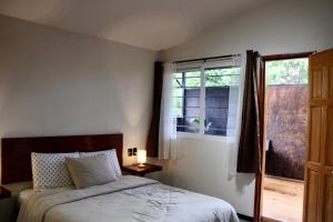 a bedroom with a bed and a window at Luffa Hostel in Santa Lucía
