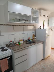 a kitchen with white cabinets and a sink at Escalera del éxito Villa Ramallo in Estación Ramallo