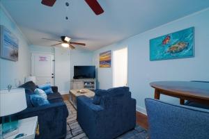a living room with two blue couches and a table at Dolphin Retreat in Brunswick