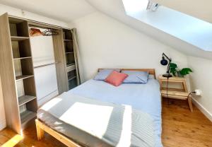 a small bedroom with a bed and shelves at Le petit nid rouennais in Rouen