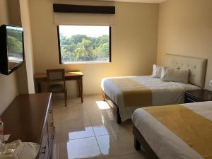 Cette chambre comprend 2 lits et une fenêtre. dans l'établissement Hotel Del Viajero, à Ciudad del Carmen