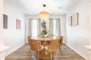 a dining room with a wooden table and chairs at Greenway Oasis 3BR home in Hidden Oaks
