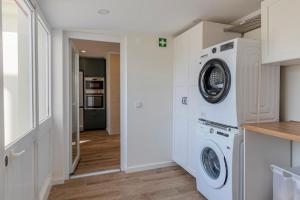 a white laundry room with a washer and dryer at Vivenda Verivitor - Saltwater Pool, Garden, BBQ & Tennis Court in Sesimbra