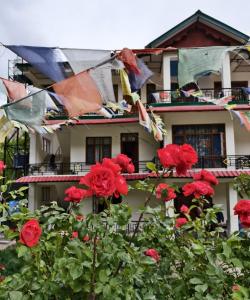 a building with red roses and prayer flags at The Moonland Homestay in Shalkār