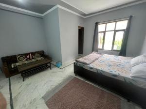 a bedroom with a bed and a window and a piano at The Moonland Homestay in Shalkār