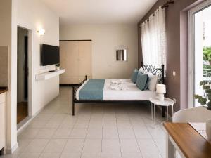 a bedroom with a bed and a television in a room at Rethymno Blue Residence in Rethymno +159 photos