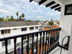 a balcony with a view of a white building at Hotel Habitat San Antonio in Cali