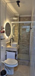 a bathroom with a toilet and a sink and a shower at Cantinho do Sol e Mar in São Vicente