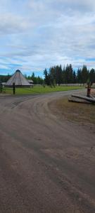 a dirt road next to a field with a pyramid at Single room - small cabin - stuga - self check in - Gällivare Koskullskulle in Koskullskulle +2 photos