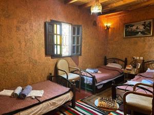 a room with three beds and a window at Riad Espace Asrir Tiznit in Tiznit