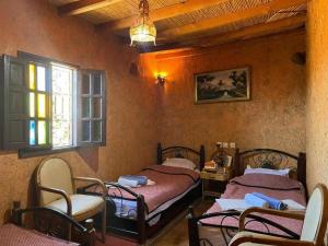 a bedroom with two beds and a window at Riad Espace Asrir Tiznit in Tiznit