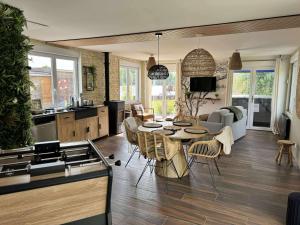 a kitchen and living room with a table and chairs at Gîte au paradis boisé in Ardres