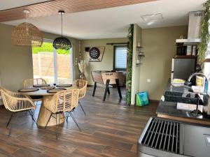 a kitchen and dining room with a table and chairs at Gîte au paradis boisé in Ardres