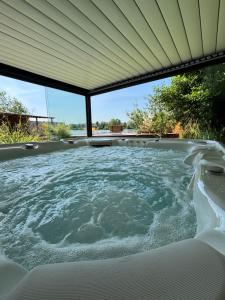 a hot tub in a backyard with a roof at Gîte au paradis boisé in Ardres