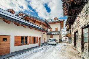 un coche aparcado en una calle entre edificios en Villa Olimpia - Stayincortina en Cortina dʼAmpezzo