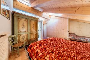 um quarto com uma cama e uma cadeira em Villa Olimpia - Stayincortina em Cortina dʼAmpezzo