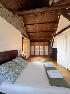 a bedroom with a large white bed with wooden ceilings at Casa Chita in Tapia de Casariego