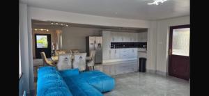 a living room with a blue couch and a kitchen at Suzies Escape in Bovevagh
