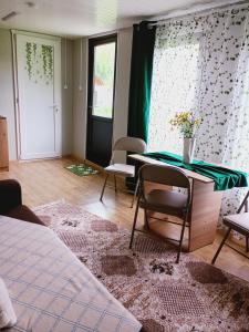 a room with a bed and a table and chairs at Căsuțele De Sub Codru in Colacu