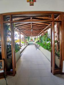 ein Flur mit Stühlen und Pflanzen in einem Gebäude in der Unterkunft El Serrano Hotel Merida in Mérida