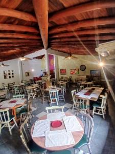 ein Restaurant mit Holzdecken, Tischen und Stühlen in der Unterkunft El Serrano Hotel Merida in Mérida