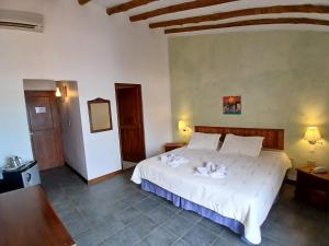 ein Schlafzimmer mit einem weißen Bett in einem Zimmer in der Unterkunft El Serrano Hotel Merida in Mérida