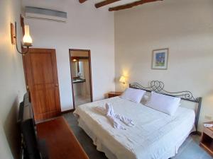 ein Schlafzimmer mit einem großen weißen Bett in einem Zimmer in der Unterkunft El Serrano Hotel Merida in Mérida + 2 Fotos