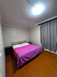 a bedroom with a bed with a purple blanket at Sweet Home 3 in Sevan