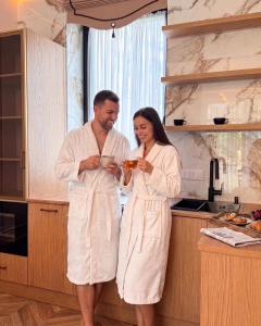 a man and a woman standing in a kitchen at Lakes Places Villas in Kyiv +24 photos