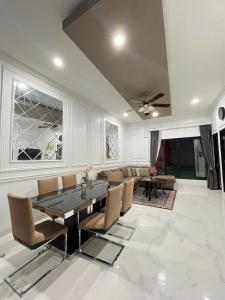 a dining room with a table and chairs and a couch at Nameera house in Makassar