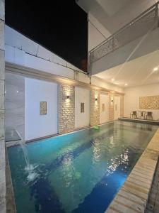 a swimming pool in a large room with at Nameera house in Makassar