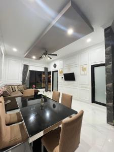 a dining room and living room with a table and chairs at Nameera house in Makassar
