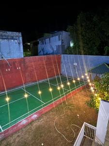 a tennis court at night with lights on it at Nameera house in Makassar