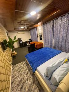 a bedroom with a large bed with a blue blanket at Arrabella Masaki in Dar es Salaam +34 photos