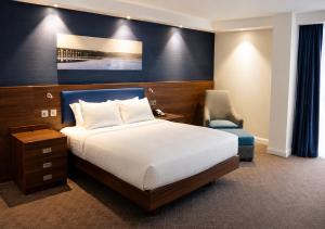 a hotel room with a bed and a chair at Hampton by Hilton Dundee City Centre in Dundee +28 photos