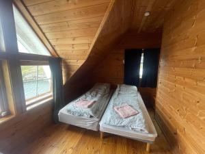 a room with two beds in a log cabin at Nautnes Costal Heaven in Nautnes